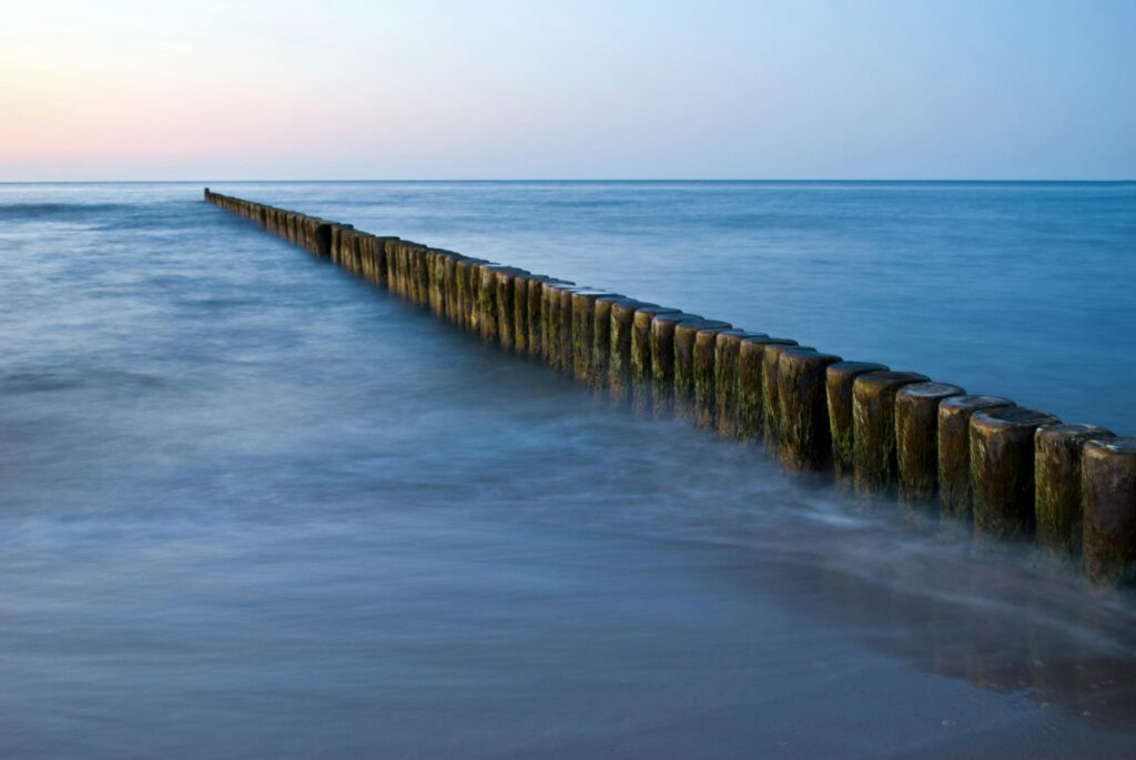 groynes-sea-baltic-sea-beach-landscape-53560-53560 Peaceful Baltic Sea view with groynes at sunset, showcasing calm waters and a pastel sky.